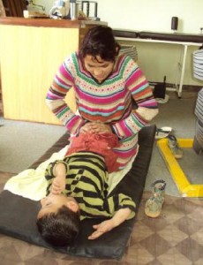 Ganga, manager helping a patient with physio